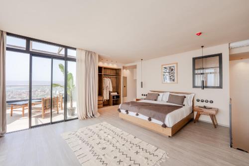 a bedroom with a large bed and a large window at Nobi Boutique Surf Hotel Taghazout in Tamraght Ouzdar