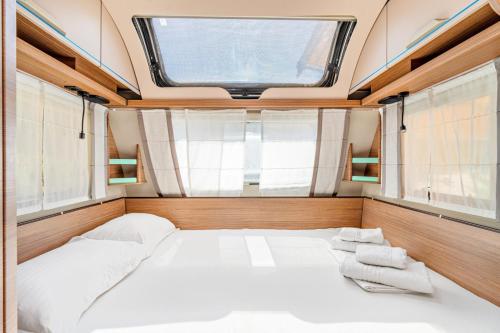 a large bed in a room with a window at Armenistis Mediterranean Camping Village in Sarti