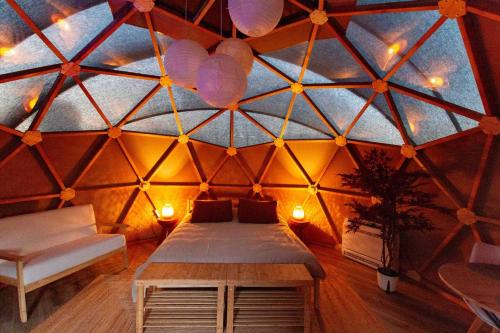 een kamer met een bed in een yurt met verlichting bij Dôme du levant in Holving