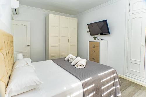una camera da letto bianca con un letto e asciugamani di Villa Daniela a Almería