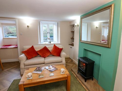 een woonkamer met een bank en een houtkachel bij The Old Dairy in Richmond