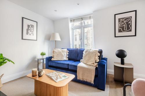 a living room with a blue couch and a table at BnBNova - 1BR - Westminster & Big Ben Nearby in London