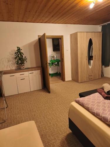 a bedroom with a bed and a table and a door at Haus Kraus in Bayerisch Eisenstein