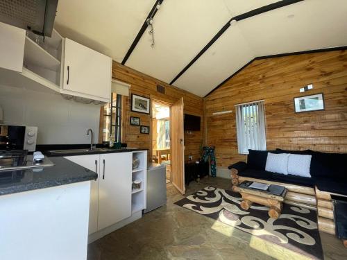 eine Küche und ein Wohnzimmer mit einem Sofa in der Unterkunft Wooden Cottage for 5 Near Lake Naivasha, Elwai Visitor Centre in Heni Village