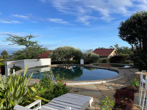ein Pool mit einer Bank im Hof in der Unterkunft Wooden Cottage for 5 Near Lake Naivasha, Elwai Visitor Centre in Heni Village