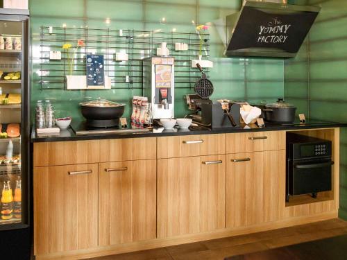 a kitchen with wooden cabinets and a counter top at Aparthotel Adagio Muenchen City in Munich