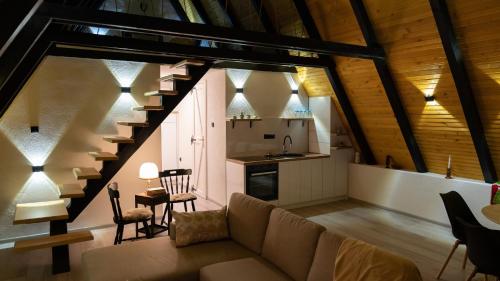 a living room with a couch and a staircase at Green Zone - Vikendica in Dubrave Gornje