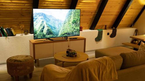 a living room with a flat screen tv in a room at Green Zone - Vikendica in Dubrave Gornje