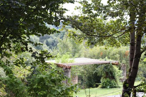 Un jardín con una pérgola de madera entre los árboles. en O Coeur d'Anaïah, en Laval-sur-Doulon