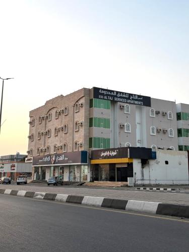 un grande edificio sul lato di una strada di hotel asis altaaj a Baish