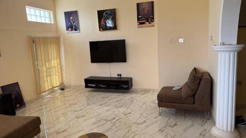 a living room with a flat screen tv on the wall at Entire First Floor with 3 en-suite bedrooms in Anaji