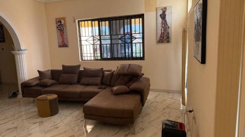 a living room with a couch and a chair and a window at Entire First Floor with 3 en-suite bedrooms in Anaji