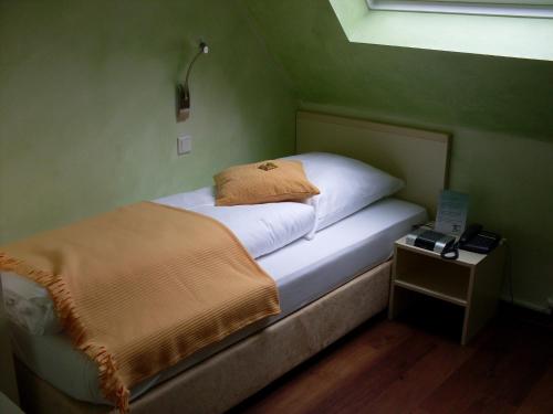 a bedroom with a bed and a night stand with a laptop at Waldhotel Brand's Busch in Bielefeld