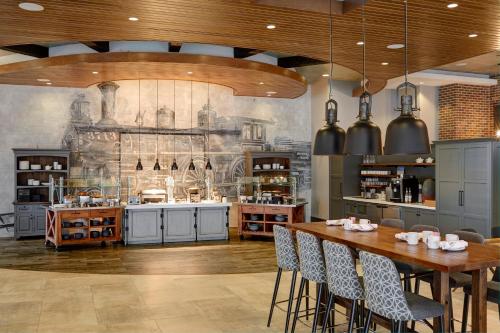 a large kitchen with a table and chairs at Archer Hotel Boston/Burlington in Burlington