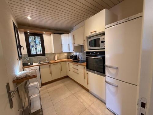 a kitchen with a white refrigerator and a microwave at 6AMB38 Superbe Villa avec terrasses dans résidence avec piscine commune in Collioure