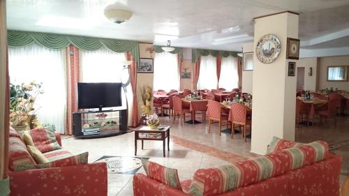 a living room with red furniture and a dining room at Hotel Holiday House in San Giovanni Rotondo