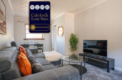 a living room with a couch and a tv at Carradale House in Falkirk