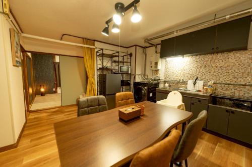 a kitchen and dining room with a table and chairs at BUDDY HOUSE - Newコスパ重視! サンタプレゼントパーク10分! カムイリンクス28分! コンビニ徒歩3分! 旭川鷹栖インター5分! 商業施設すぐ! in Asahikawa