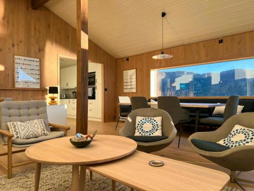 FisterにあるPanorama Cabin With Trails From Door In Ryfylkeのリビングルーム(椅子、テーブル付)、ダイニングルーム