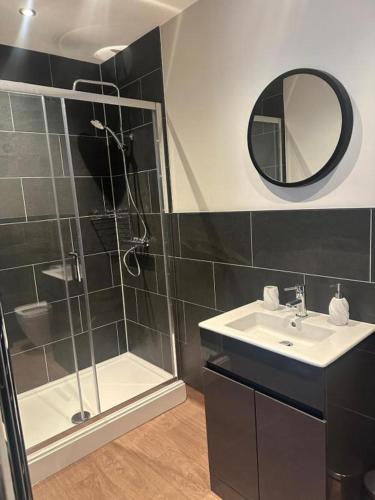 a bathroom with a shower and a sink and a mirror at The Briery in Workington