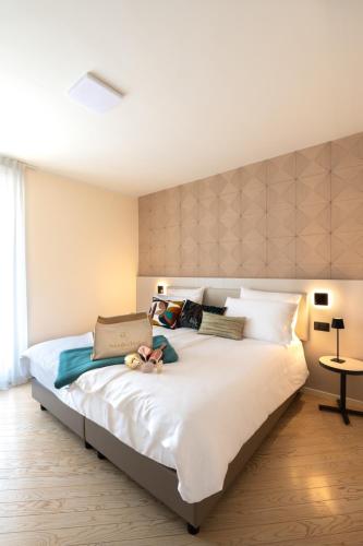 a bedroom with a large white bed with pillows at WANDERLUST VILLETTE a SCHIERA - Bardolino, Lago di Garda - Verona in Bardolino