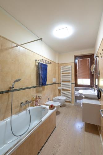 a bathroom with two sinks and a tub and two toilets at WANDERLUST VILLETTE a SCHIERA - Bardolino, Lago di Garda - Verona in Bardolino
