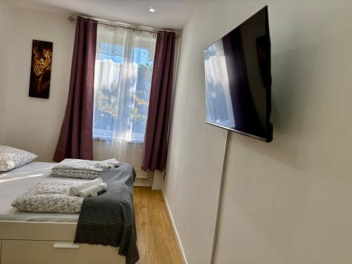 a bedroom with a bed and a tv on the wall at City Line Koblenz in Koblenz