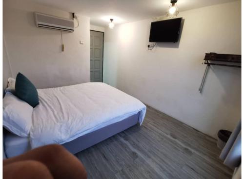 a small bedroom with a bed and a tv at Hotel O ZZZ in Kuah