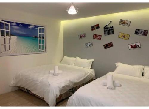 two beds in a room with pictures on the wall at Hotel O ZZZ in Kuah