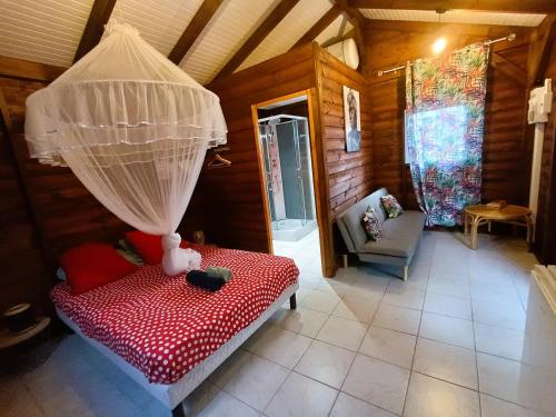 a room with a bed with a net at Gites kaz à klemence - bungalow Colibris in Anse-Bertrand