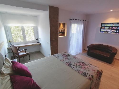 a bedroom with a bed and a chair and a window at Central 2 bedroom apartment with terrace in Girona