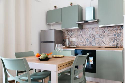 Giù in Calabria B&B - Terrazze Italiane Catanzaro Lido في كاتانزارو ليدو: مطبخ مع طاولة وكراسي خشبية