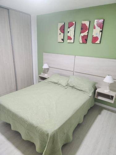 a bedroom with a large bed and three paintings on the wall at Traslasierra Champaquí Deptos in Villa Dolores