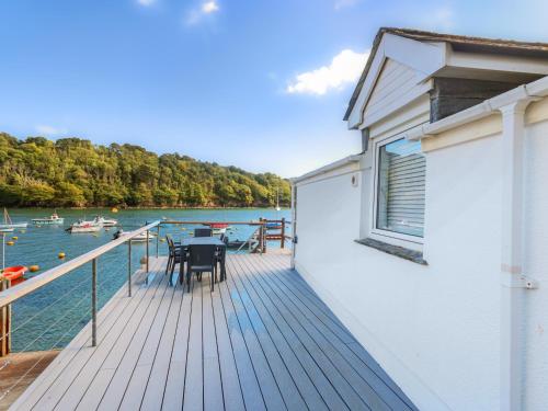 een dek met een tafel en stoelen op een boot bij Tarquins in Fowey