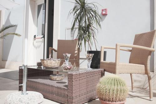 Boutique Hotel Molo S Lucia في سيراكوزا: فناء مع كرسيين وطاولة مع صبار
