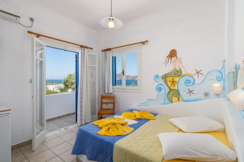 Ein Schlafzimmer mit zwei Betten und einem Meerjungfrauen-Wandbild an der Wand in der Unterkunft Apollon Rooms in Pollonia