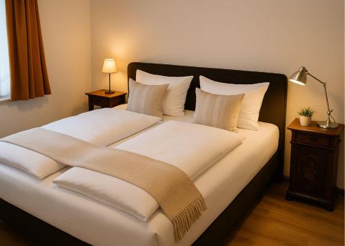 a bedroom with a large bed with white sheets and pillows at Hotel Sternen in Gurtnellen