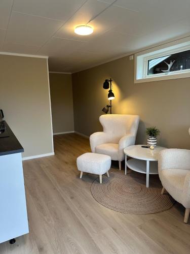 een woonkamer met twee stoelen en een tafel bij Modern studio apartment with wood-fired sauna in Bjørkheim
