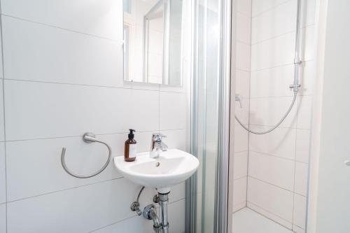 Bad Ems City Apartment nahe Therme und Zentrum في باد إمس: حمام أبيض مع حوض ودش