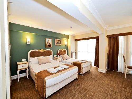 ein Schlafzimmer mit zwei Betten und einer grünen Wand in der Unterkunft Elysion Hotel in Istanbul