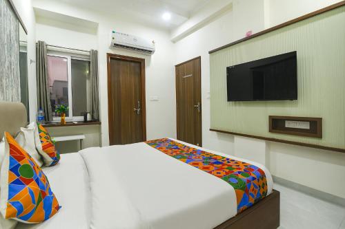 ein Schlafzimmer mit einem Bett und einem Flachbildfernseher in der Unterkunft FabHotel Jai Palace Comfortable Stay in Jaipur
