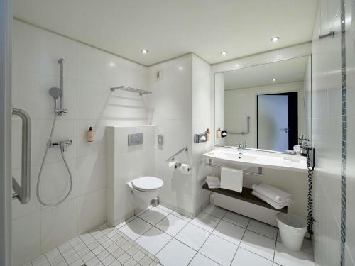 um banheiro com pia, vaso sanitário e chuveiro em Mercure Chartres Centre Cathedrale em Chartres