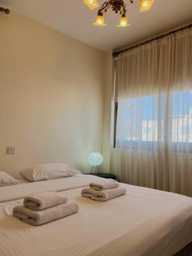 two beds in a bedroom with towels on them at DANAOS 2 COMPLEX APARTMENT - By NOMA STAYS Cyprus in Paphos