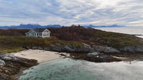 een huis op een eiland met strand en water bij Breathe - Seafront Hideaway in Skrollsvika