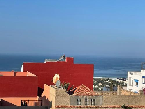 ein rotes Gebäude mit dem Ozean im Hintergrund in der Unterkunft Modern apartment in Agadir