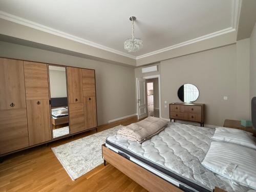 duża sypialnia z łóżkiem i komodą w obiekcie White City Apartment w mieście Baku
