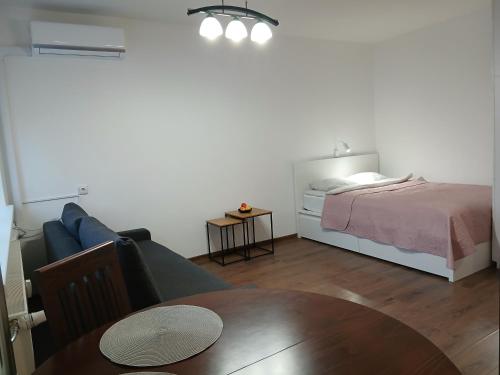 a living room with a bed and a couch and a table at Alytus Studio 45 in Alytus