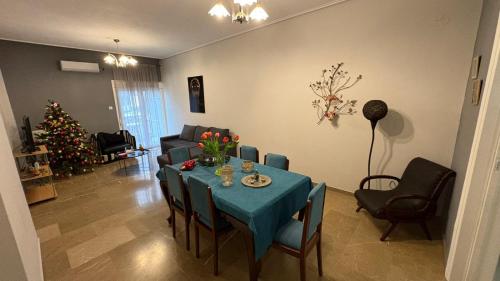 a living room with a table and a christmas tree at MARIAS APARTMENT TRIKALa in Tríkala