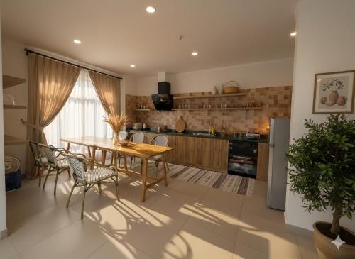 a kitchen with a wooden table and chairs in a room at Homestay Santoni Mũi Né in Mui Ne