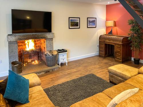 ein Wohnzimmer mit einem Kamin und einem Flachbild-TV in der Unterkunft Home Farm - The Dairy -Uk34626 in Dunragit
